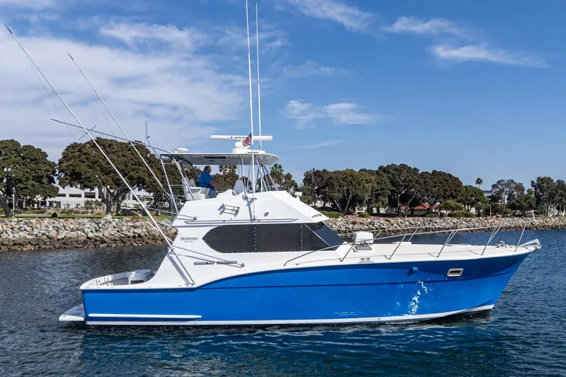  Yacht Photos Pics 1974 Hatteras Convertible Sportfisher boat on water, blue hull, clear sky background.