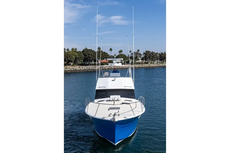  Yacht Photos Pics 1974 Hatteras Convertible Sportfisher boat on calm water, clear sky background.