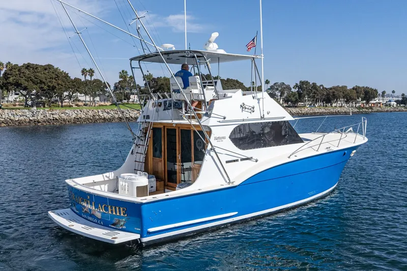  Yacht Photos Pics 1974 Hatteras Convertible Sportfisher boat on water, blue and white design, coastal background.