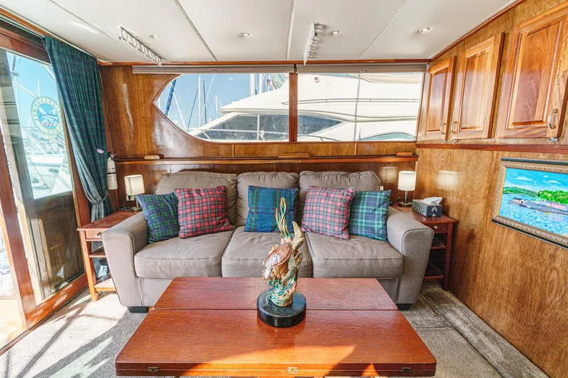  Yacht Photos Pics 1974 Hatteras Convertible Sportfisher interior with cozy sofa, plaid pillows, and wooden cabinetry.