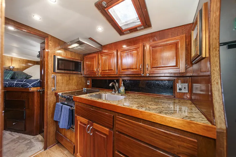  Yacht Photos Pics 1974 Hatteras Convertible Sportfisher interior with wooden cabinetry and granite countertops.