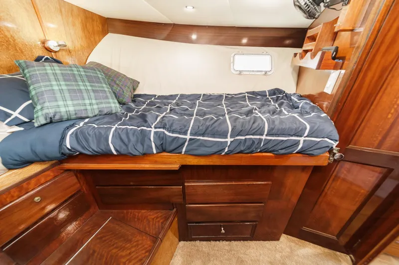  Yacht Photos Pics 1974 Hatteras Convertible Sportfisher cabin with cozy bed and wooden storage drawers.