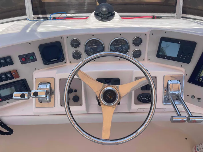 Lost Bouys Yacht Photos Pics 2004 Regal Commodore 3880 helm with steering wheel, gauges, and navigation controls.