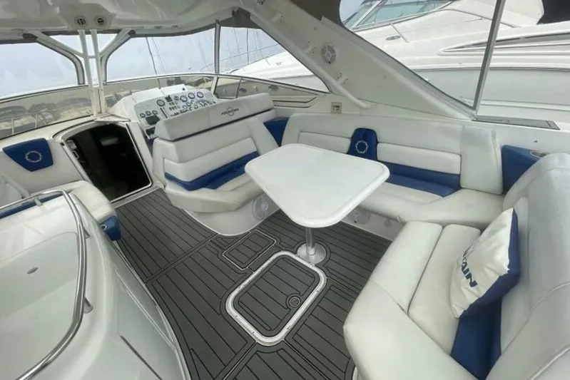  Yacht Photos Pics 2006 Fountain 48 Express Cruiser interior with white and blue seating, table, and modern design.