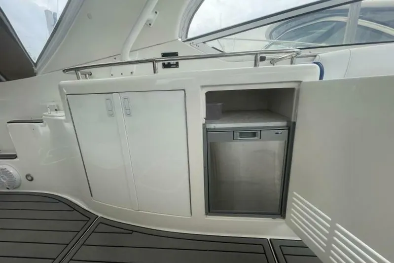  Yacht Photos Pics 2006 Fountain 48 Express Cruiser interior with mini fridge and storage cabinets.