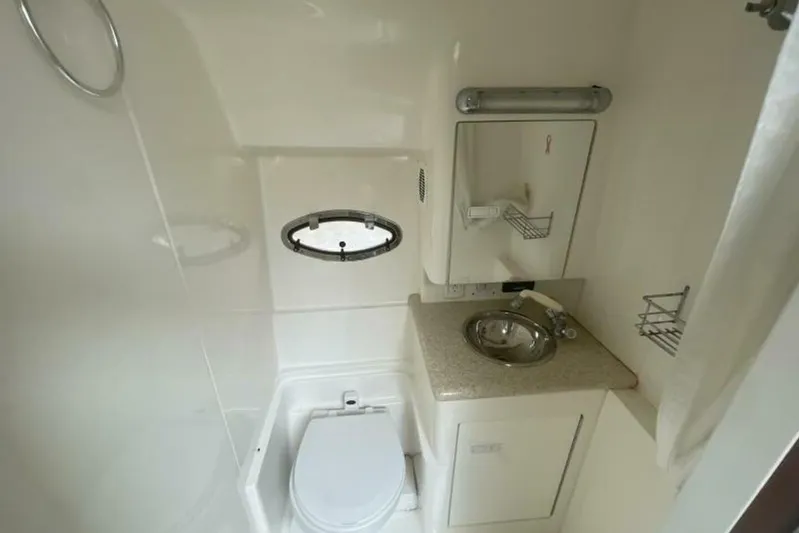  Yacht Photos Pics 2006 Fountain 48 Express Cruiser bathroom with sink, toilet, and porthole window.