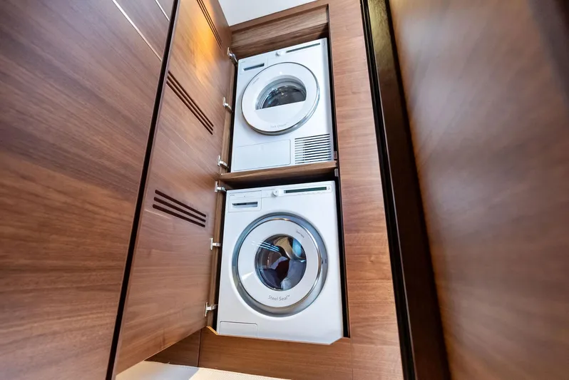 Seaquel Yacht Photos Pics Stacked washer and dryer in 2024 Princess Y72 Motor Yacht's wooden cabinet.