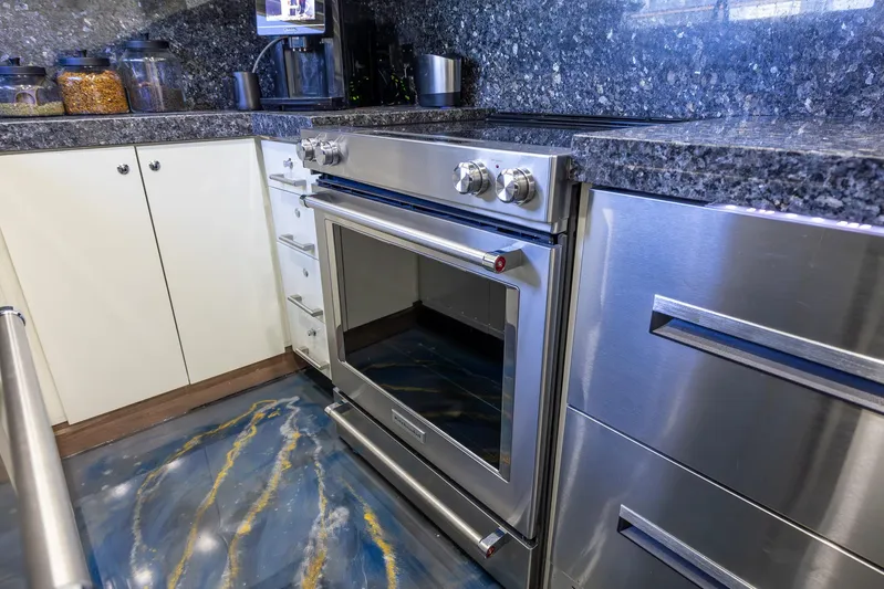 Kaya Yacht Photos Pics Stainless steel Johnson 87 oven in modern kitchen, granite countertops, blue marbled floor.