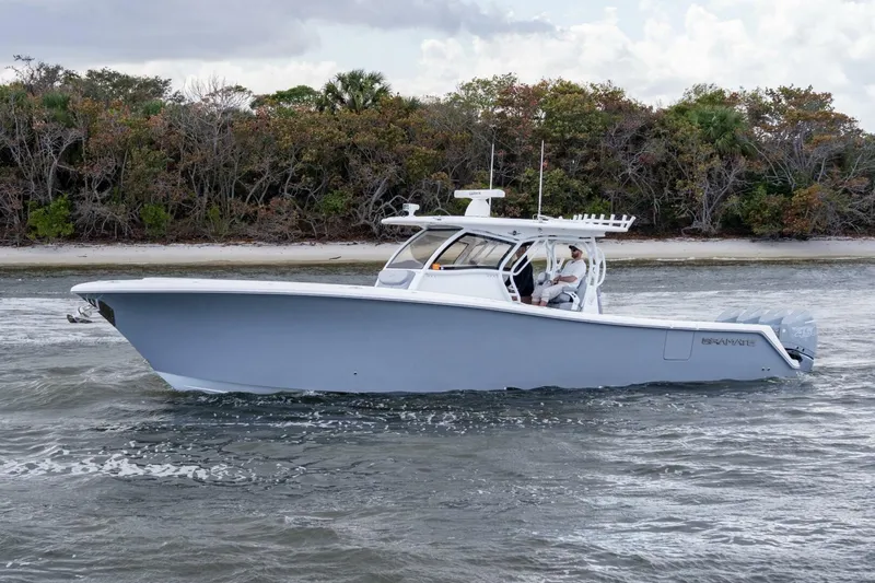 Bramate Yacht Photos Pics 2023 Blackwater High-Performance boat cruising near a forested shoreline.