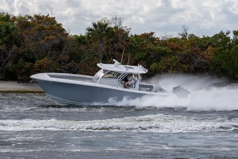 Bramate Yacht Photos Pics 2023 Blackwater High-Performance boat speeding on water near lush shoreline.