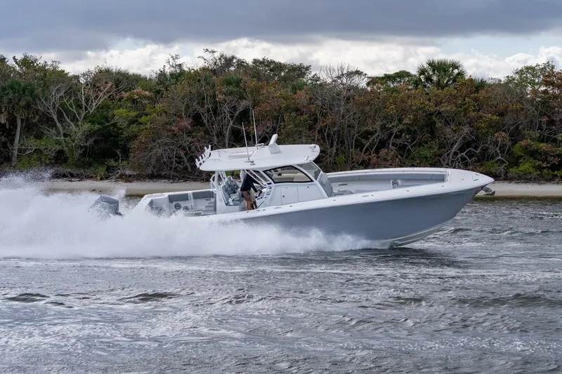 Bramate Yacht Photos Pics 2023 Blackwater High-Performance boat speeding on water near a forested shoreline.