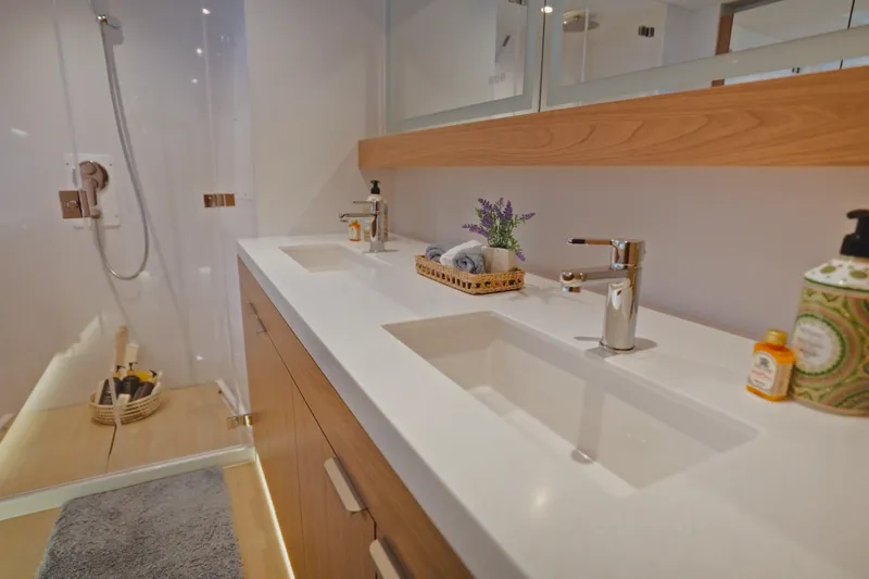 Stills Yacht Photos Pics Modern bathroom with dual sinks, wooden accents, and a glass shower in a 2026 Bali 5.2 model.