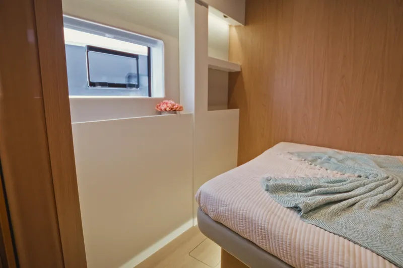 Stills Yacht Photos Pics Modern interior of 2026 Bali 5.2 yacht cabin with cozy bed and window.