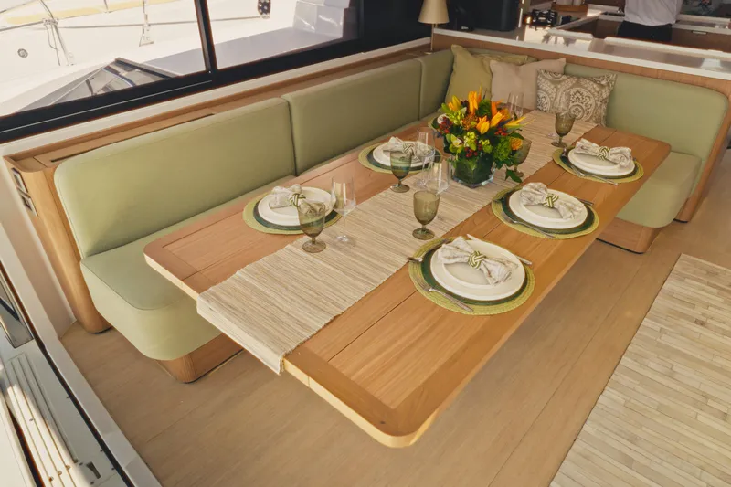 Stills Yacht Photos Pics Elegant dining setup on 2026 Bali 5.2 yacht with floral centerpiece and green accents.