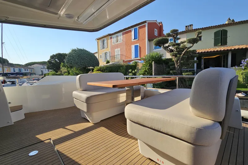 Shadow Yacht Photos Pics Luxury 2024 Prestige F4 yacht deck with elegant seating and scenic waterfront view.