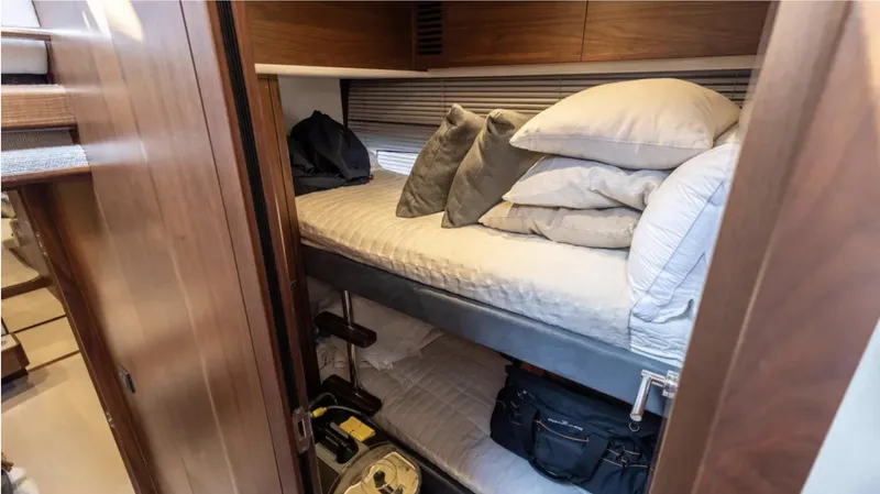  Yacht Photos Pics Cozy cabin interior of 2022 Princess S66 yacht with bunk beds and wooden finish.