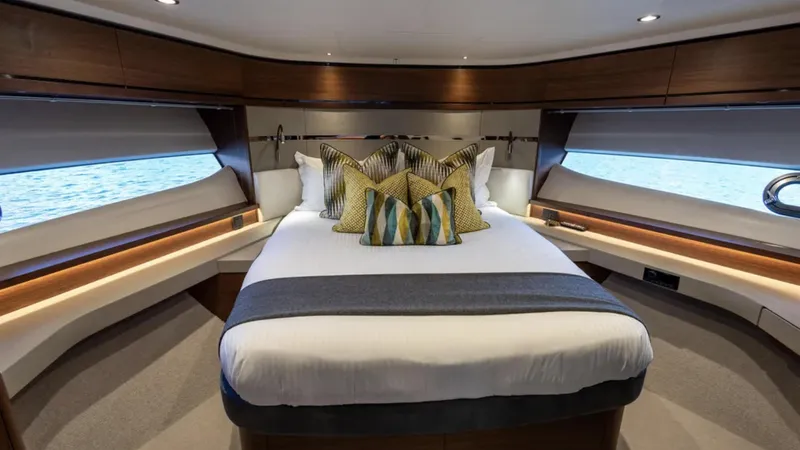  Yacht Photos Pics Luxurious bedroom interior of 2022 Princess S66 yacht with elegant bedding and panoramic windows.