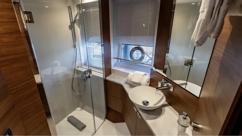  Yacht Photos Pics Luxurious bathroom in 2022 Princess S66 yacht with modern fixtures and elegant wood accents.