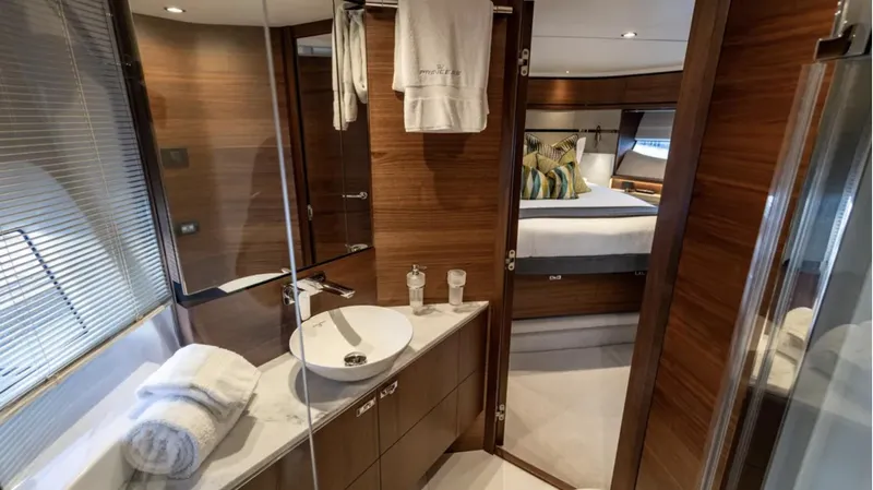  Yacht Photos Pics Luxurious bathroom and bedroom interior of 2022 Princess S66 yacht, featuring elegant wood finishes.
