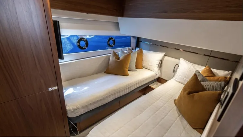  Yacht Photos Pics Luxurious cabin interior of 2022 Princess S66 yacht with cozy beds and elegant decor.