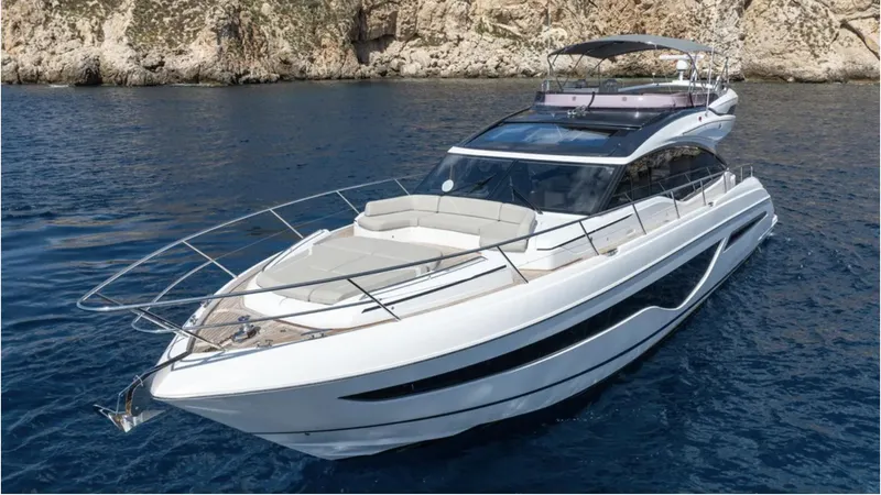  Yacht Photos Pics 2022 Princess S66 yacht cruising on clear blue water near rocky cliffs.