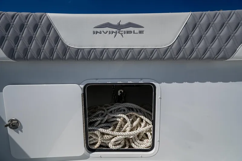  Yacht Photos Pics 2025 Invincible 33 Catamaran storage compartment with ropes, featuring logo and quilted upholstery.