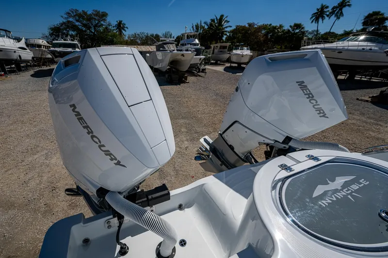  Yacht Photos Pics 2025 Invincible 33 Catamaran with dual Mercury outboard engines in a boatyard setting.