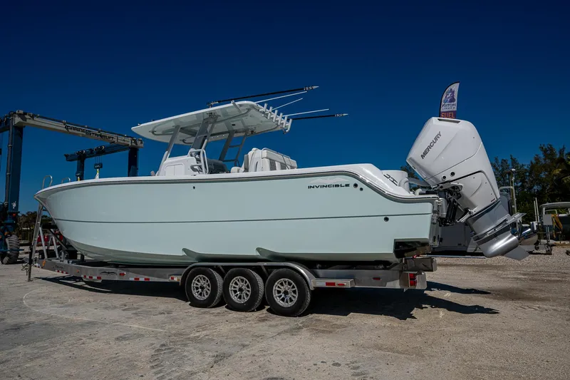  Yacht Photos Pics 2025 Invincible 33 Catamaran on trailer, side view, clear sky background.