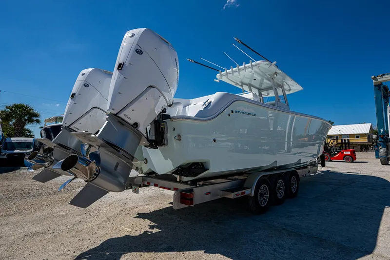  Yacht Photos Pics 2025 Invincible 33 Catamaran on trailer, featuring dual outboard engines, under clear blue sky.