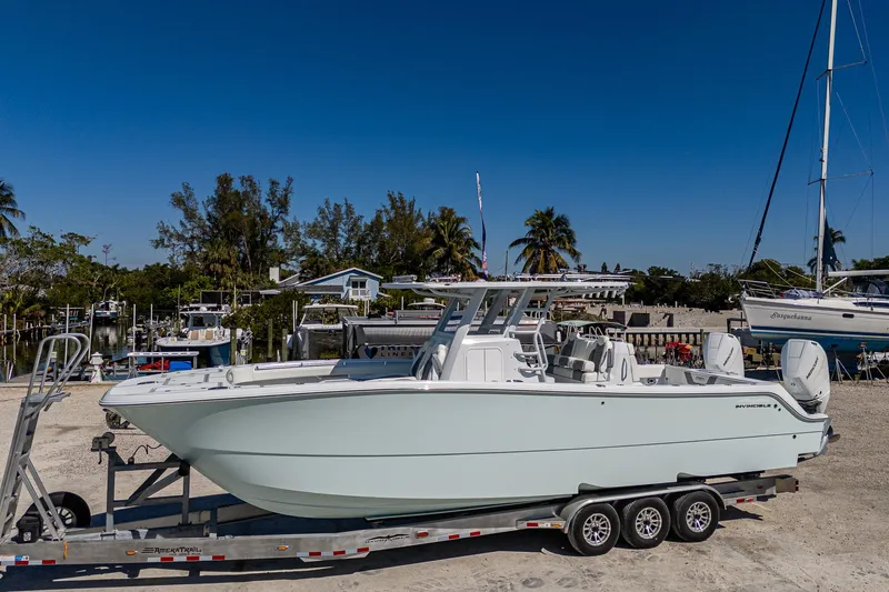  Yacht Photos Pics 2025 Invincible 33 Catamaran on trailer, parked outdoors with clear blue sky.