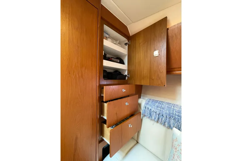 Sasea Yacht Photos Pics Interior storage of 2009 Tiara Yachts 4200 Open, featuring wooden cabinets and drawers.