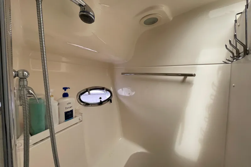Sasea Yacht Photos Pics Shower area in 2009 Tiara Yachts 4200 Open, featuring a porthole and toiletries.