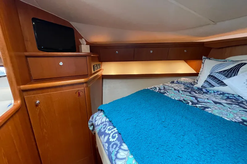 Sasea Yacht Photos Pics Luxurious cabin interior of 2009 Tiara Yachts 4200 Open with cozy bedding and wood cabinetry.