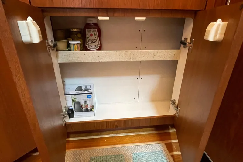 Sasea Yacht Photos Pics Open wooden cabinet on 2009 Tiara Yachts 4200 Open, containing condiments and a box.