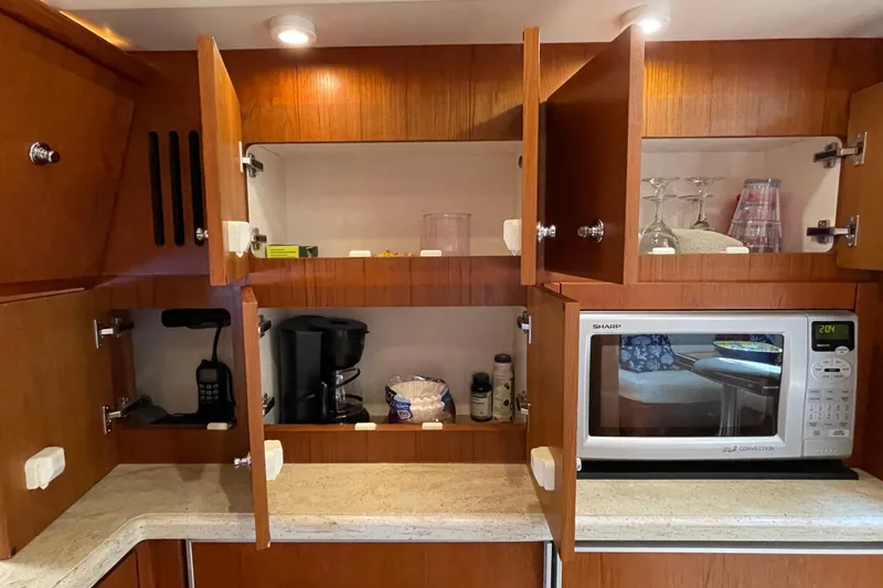 Sasea Yacht Photos Pics 2009 Tiara Yachts 4200 Open kitchen with wooden cabinets, microwave, and coffee maker.