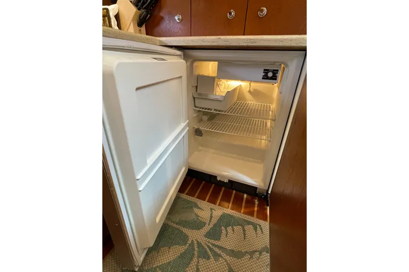 Sasea Yacht Photos Pics Open refrigerator inside 2009 Tiara Yachts 4200 Open, showcasing interior shelves and lighting.