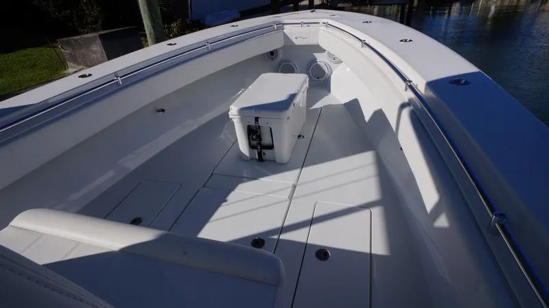  Yacht Photos Pics 2023 Contender 32 ST boat interior with seating and storage, docked by the water.
