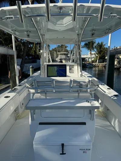  Yacht Photos Pics 2023 Contender 32 ST boat interior with navigation system and seating, docked by the water.