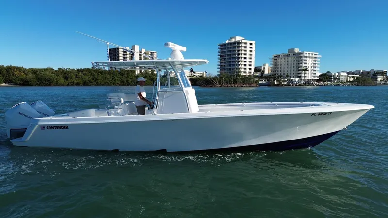  Yacht Photos Pics 2023 Contender 32 ST boat cruising on water with cityscape background.