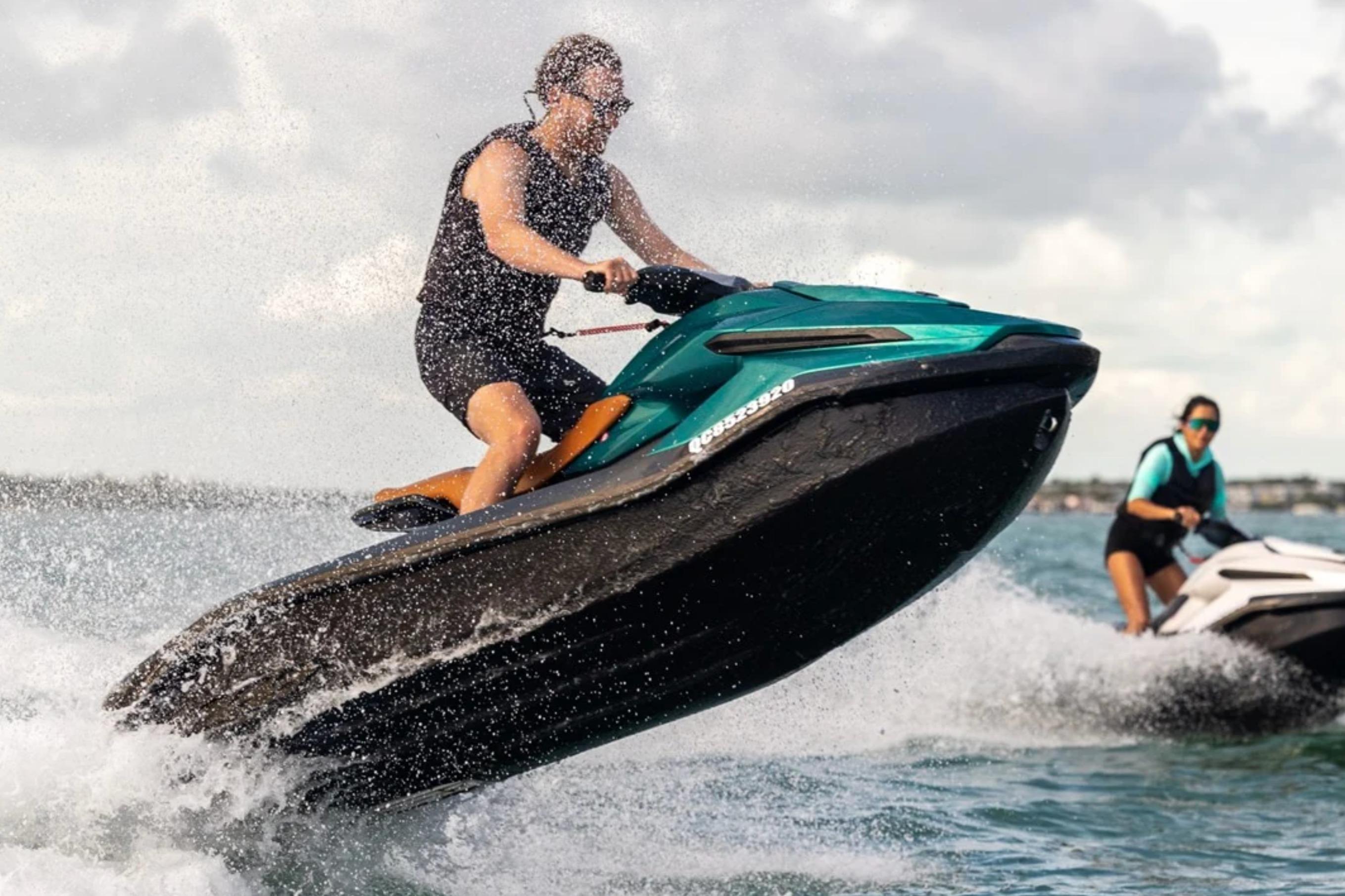 Man riding 2025 Taiga Orca P2 jet ski, leaping over waves, with another rider in the background.
