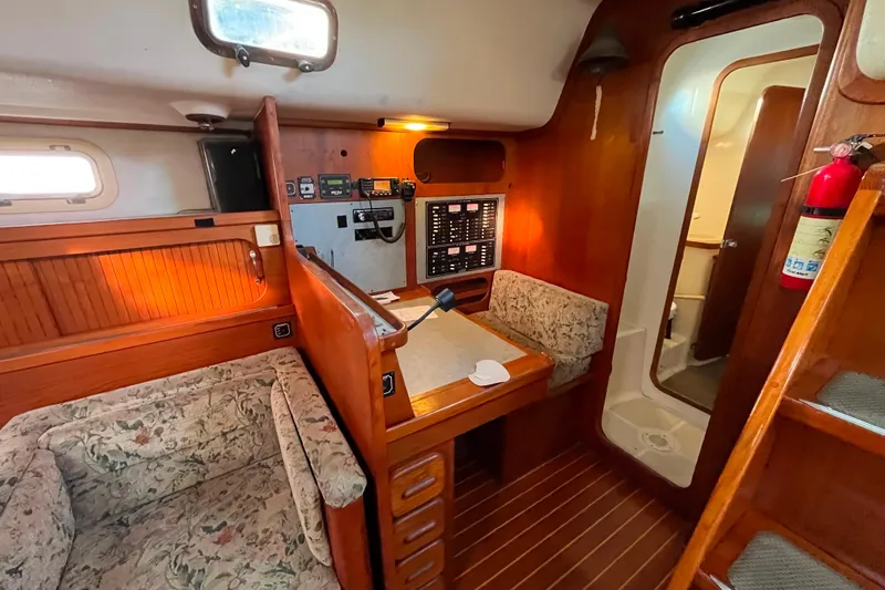 "destination Unknown" Yacht Photos Pics Interior of 1985 Caliber 47LRC sailboat with wood paneling and navigation equipment.