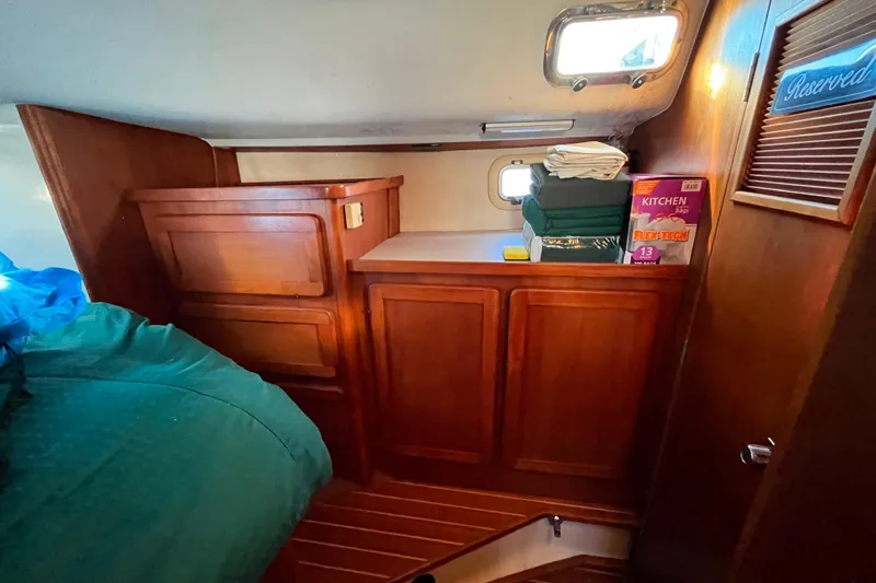 "destination Unknown" Yacht Photos Pics Interior of 1985 Caliber 47LRC yacht with wooden cabinets and storage area.