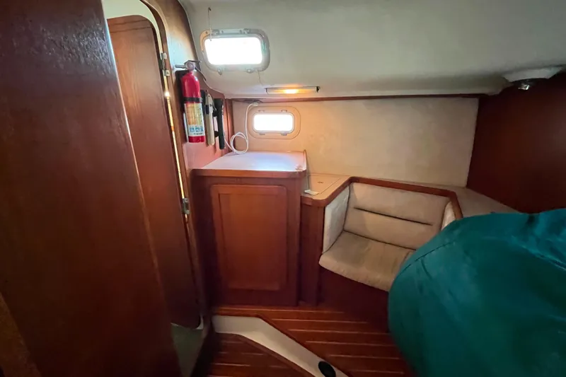"destination Unknown" Yacht Photos Pics 1985 Caliber 47LRC yacht interior with wooden cabinetry and seating area.