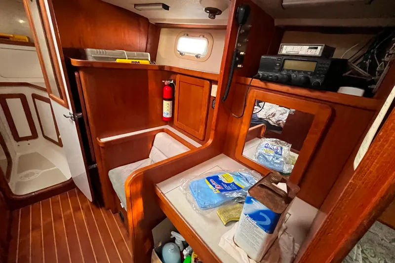 "destination Unknown" Yacht Photos Pics Interior of 1985 Caliber 47LRC sailboat with wooden cabinetry and navigation equipment.