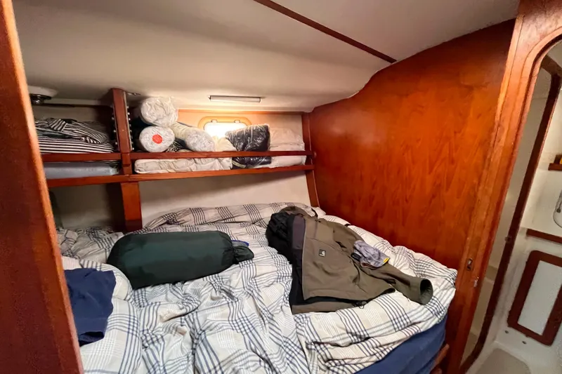 "destination Unknown" Yacht Photos Pics Cozy cabin interior of 1985 Caliber 47LRC sailboat with bed and storage shelves.