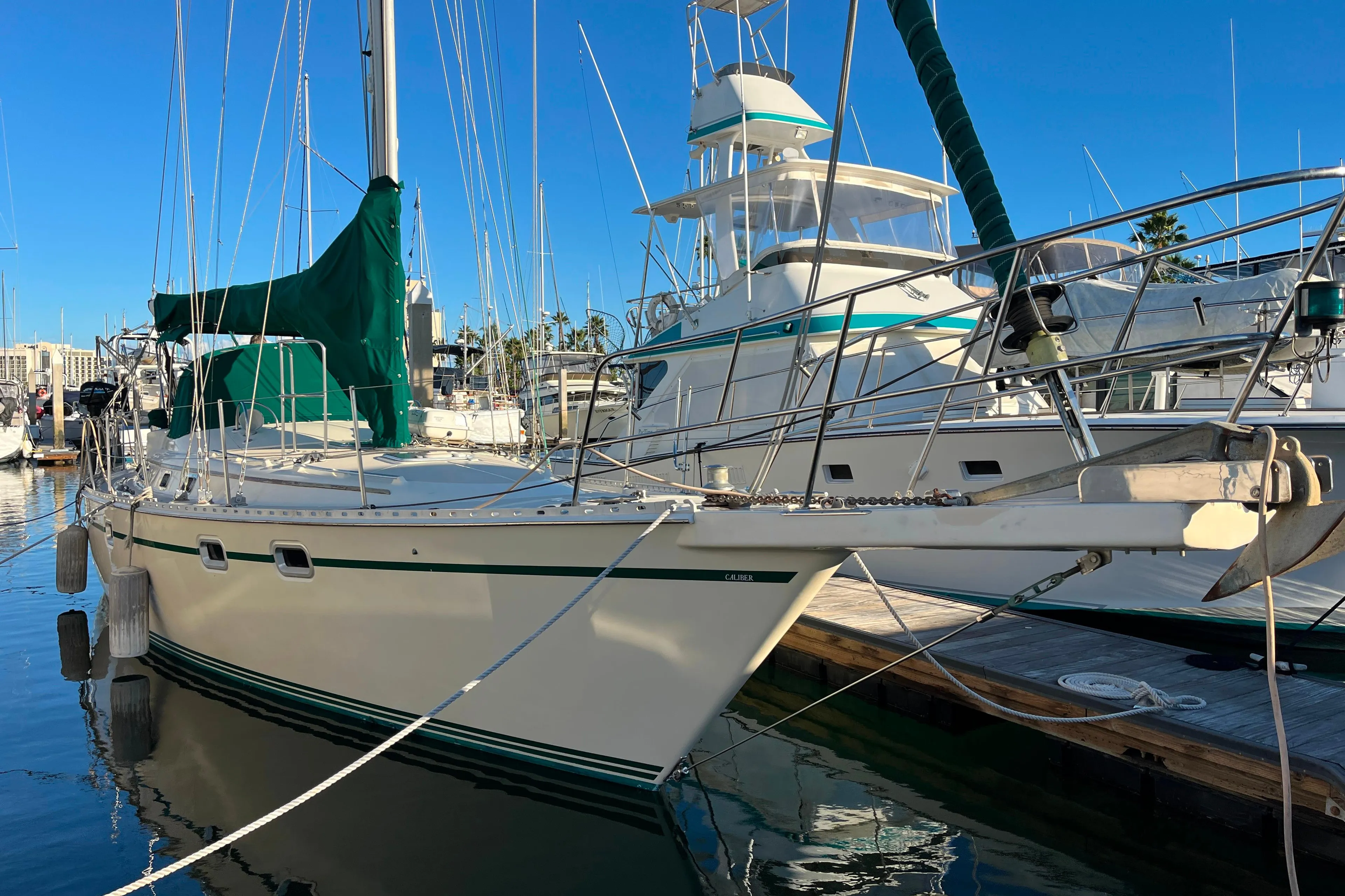 1985 Caliber 47LRC sailboat docked at marina under clear blue sky.