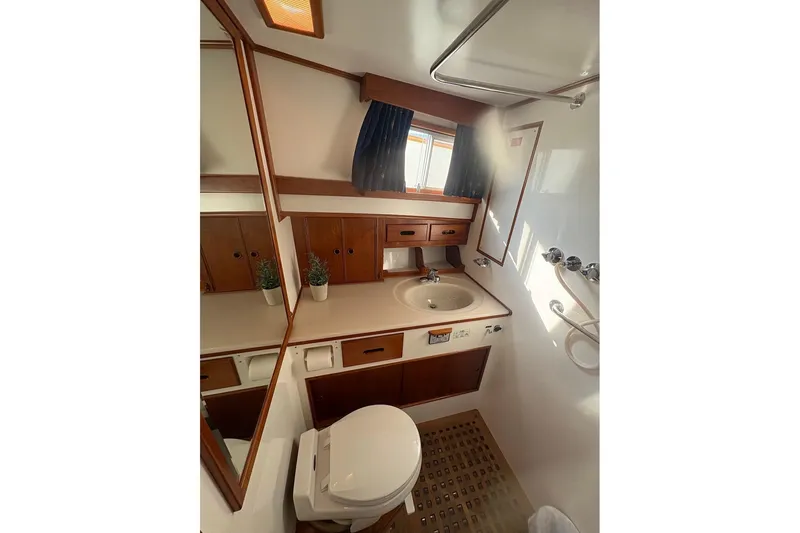 Margo Yacht Photos Pics Bathroom interior of 1996 Grand Banks 42 Classic yacht, featuring sink, toilet, and wooden cabinetry.