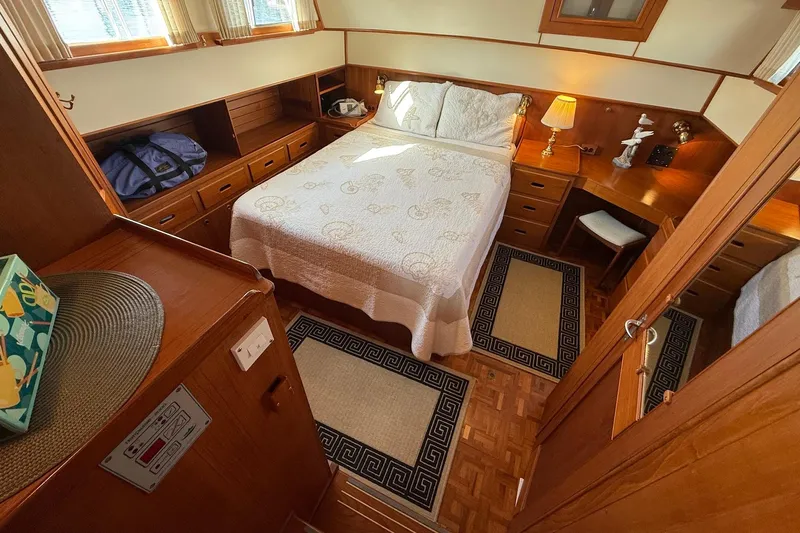 Margo Yacht Photos Pics Cozy bedroom interior of a 1996 Grand Banks 42 Classic yacht with wooden furnishings.