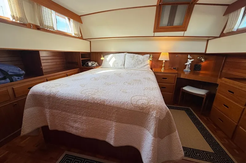 Margo Yacht Photos Pics Cozy bedroom in a 1996 Grand Banks 42 Classic yacht with wood accents and natural light.