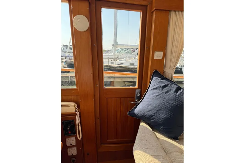 Margo Yacht Photos Pics Interior of 1996 Grand Banks 42 Classic yacht with wooden door and blue cushion.